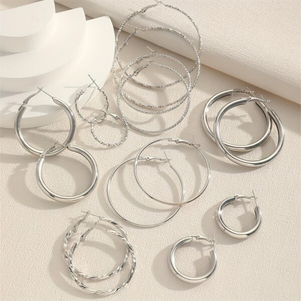 A Set Of 8 Pairs Of Simple And Stylish Twisted Wave Sparkling Earrings In Golden And Silvery Colors. - Image 4