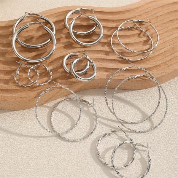 A Set Of 8 Pairs Of Simple And Stylish Twisted Wave Sparkling Earrings In Golden And Silvery Colors. - Image 10